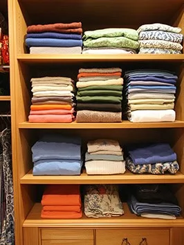 clothes folded and stored in a closet